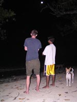 men and dog in the beach